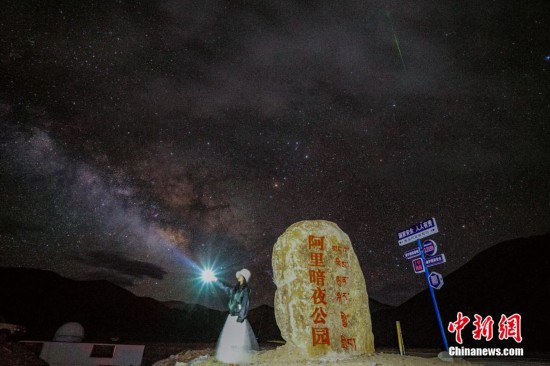 圖為6月20日晚，游客“打卡”西藏阿里暗夜公園，天上是銀河與流星（右上角）。曹枝清 攝