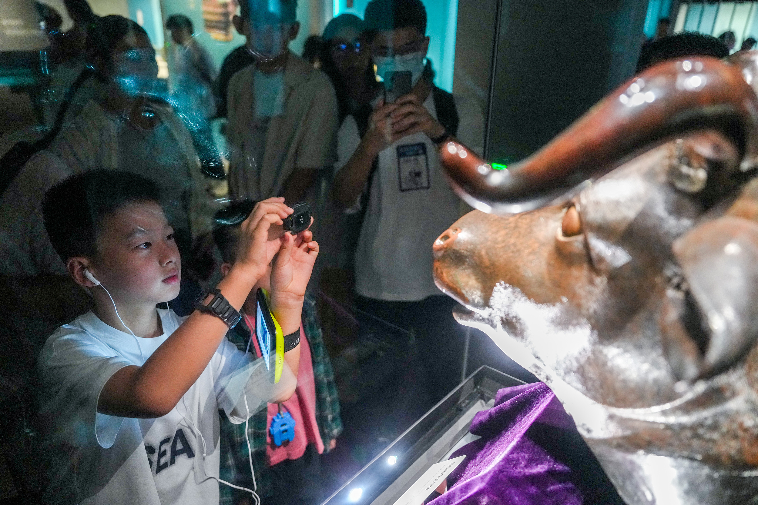 2025年6月,參加研學(xué)游的孩子在安徽博物院蜀山館參觀圓明園牛首銅像。(圖片來源:視覺中國)