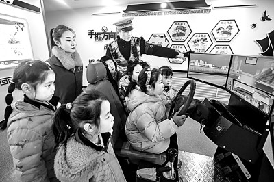 山東省榮成市公安局道路交通安全宣傳教育基地，交警帶領(lǐng)小學(xué)生現(xiàn)場體驗?zāi)M駕駛。新華社發(fā)