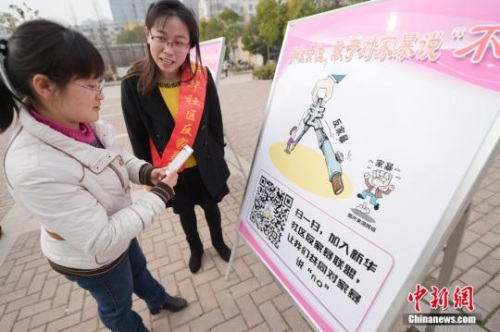 資料圖：今年3月8日，安徽合肥新華社區(qū)志愿者夏一瓊(右)向市民普及反家暴相關(guān)法律知識(shí)。鐘欣 攝